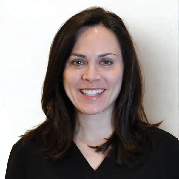 Young Woman Smiling By Green Wall